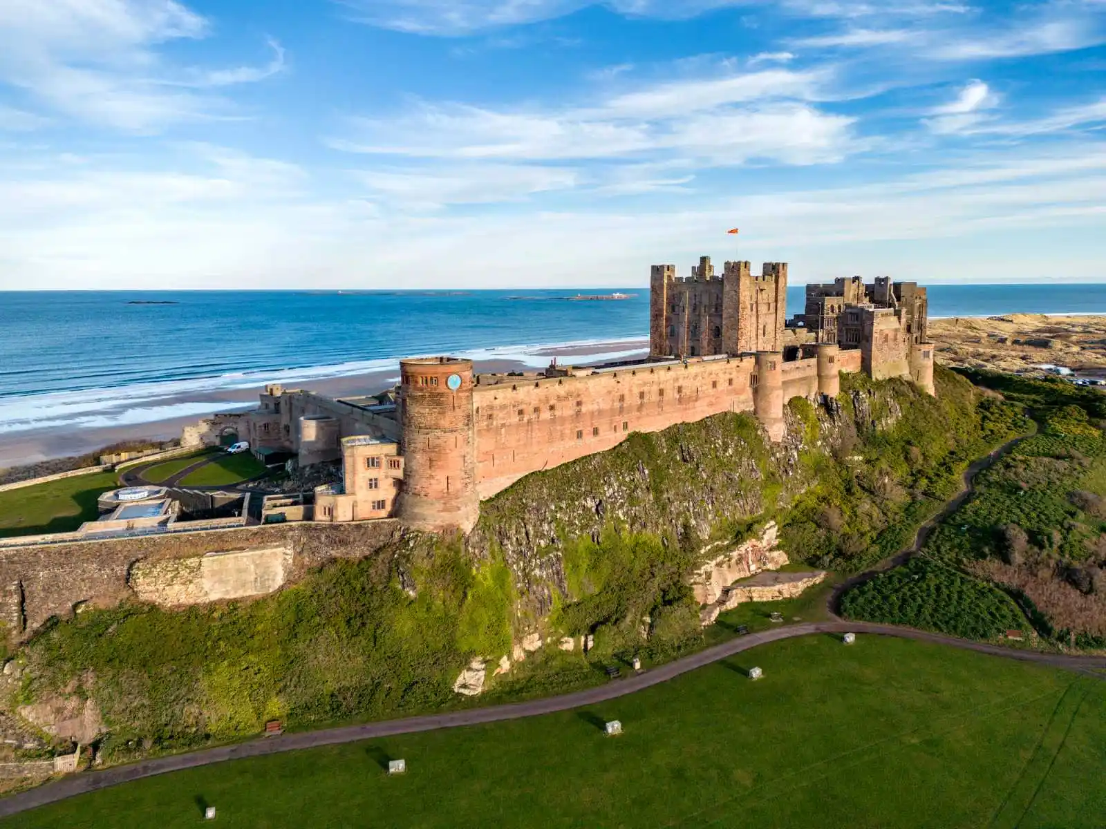 Bamburgh Castle se rozkládá na skalním útesu s výhledem na Severní moře a nekonečné pobřeží.
